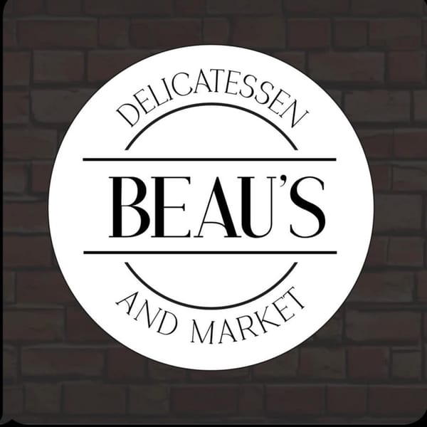 Beau's Delicatessen and Market logo, a white circle with black text on a brick background.