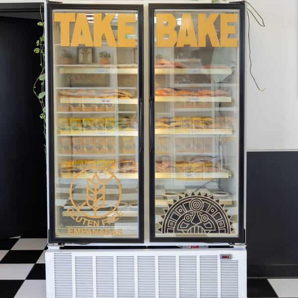 A MASA Empanadas 'Take & Bake' freezer filled with packaged empanadas, including gluten-free options.